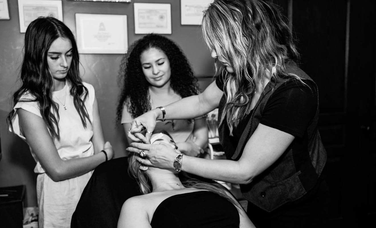 Alisa teaching students a lash and brow technique