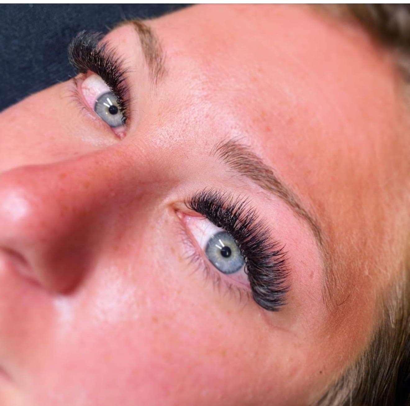 Close-up of striking blue eyes with a full natural-glam lash set
